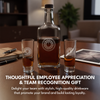 Bottle of alcohol with two shot glasses on a table, with text about employee appreciation and team recognition gift.