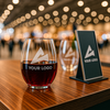 Custom etched wine glass with red wine, displayed at a professional tradeshow booth – perfect for branded merchandise, client gifts, or executive events.